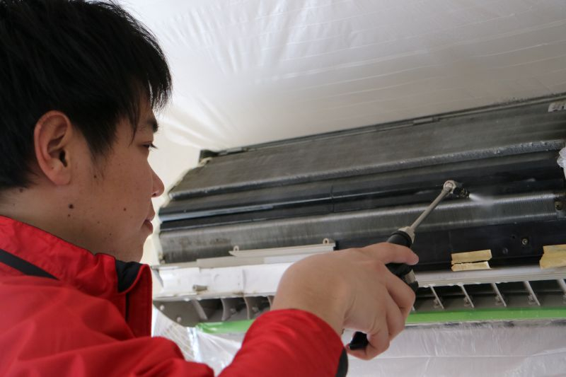 東京のおそうじ革命で学生スタッフがエアコンクリーニングの作業をしている様子